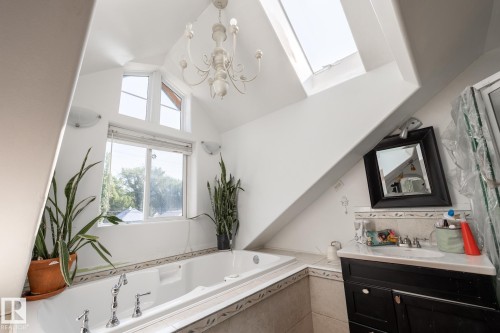 Bathroom with vanity, suspended lighting, a bath, and a skylight - 11415 85 Street, Edmonton, AB - Indoor Photo Showing Bathroom
