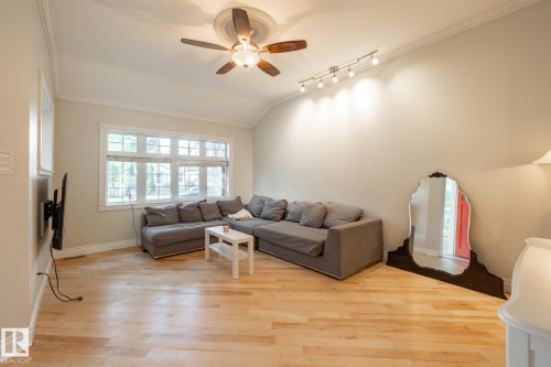 Living area with vaulted ceiling, light wood-style flooring, a ceiling fan, ornamental molding, and rail lighting - 11415 85 Street, Edmonton, AB - Indoor Photo Showing Living Room