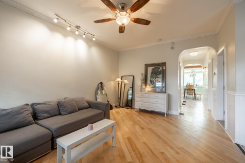 Living room with arched walkways, light wood-style flooring, ornamental molding, and a ceiling fan - 11415 85 Street, Edmonton, AB - Indoor Photo Showing Other Room