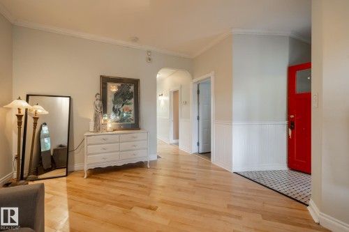 Foyer featuring crown molding, arched walkways, light wood-style flooring, and a wainscoted wall - 11415 85 Street, Edmonton, AB - Indoor Photo Showing Other Room