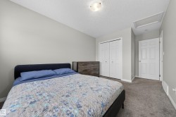 Bedroom featuring dark colored carpet, a closet, and a textured ceiling - 