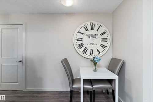 Dining room featuring dark wood-type flooring and a textured ceiling - 231 344 Windermere Road, Edmonton, AB - Indoor Photo Showing Dining Room