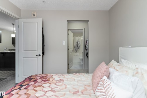 Bedroom featuring ensuite bath and a textured ceiling - 231 344 Windermere Road, Edmonton, AB - Indoor Photo Showing Bedroom