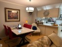 Dining area with a textured ceiling, crown molding, and light wood-style flooring - 202 18020 95 Avenue, Edmonton, AB  - Indoor Photo Showing Dining Room 