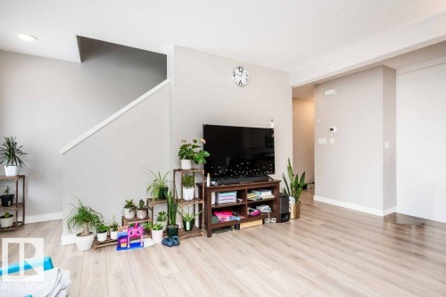 Living room featuring light wood finished floors and a textured ceiling - 96 1530 Tamarack Boulevard, Edmonton, AB - Indoor