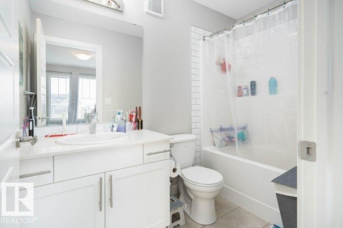 Bathroom with vanity, light tile patterned flooring, and shower / bath combo with shower curtain - 96 1530 Tamarack Boulevard, Edmonton, AB - Indoor Photo Showing Bathroom