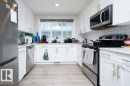 Kitchen with stainless steel appliances, white cabinetry, backsplash, light wood-style flooring, and recessed lighting - 96 1530 Tamarack Boulevard, Edmonton, AB  - Indoor Photo Showing Kitchen With Upgraded Kitchen 