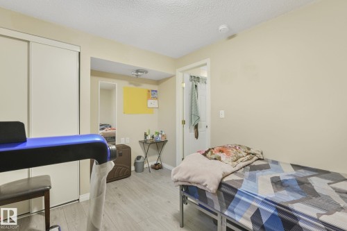 Bedroom with light wood-type flooring, a textured ceiling, and a closet - 2 Scarboro Place, St. Albert, AB - Indoor Photo Showing Bedroom