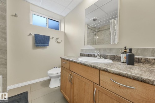 Full bathroom with a shower with curtain, vanity, light tile patterned floors, and a paneled ceiling - 2 Scarboro Place, St. Albert, AB - Indoor Photo Showing Bathroom