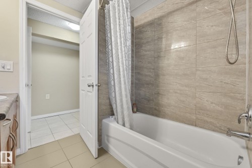 Bathroom featuring light tile patterned floors, vanity, and shower / bath combo - 2 Scarboro Place, St. Albert, AB - Indoor Photo Showing Bathroom