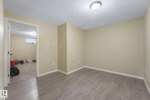 Spare room featuring a textured ceiling and light wood-type flooring - 2 Scarboro Place, St. Albert, AB - Indoor Photo Showing Other Room