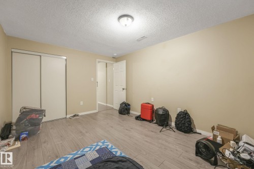 Bedroom featuring light wood-style floors, a textured ceiling, and a closet - 2 Scarboro Place, St. Albert, AB - Indoor