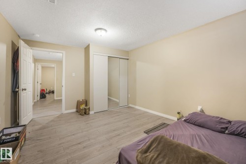 Bedroom with light wood finished floors, a closet, and a textured ceiling - 2 Scarboro Place, St. Albert, AB - Indoor Photo Showing Bedroom