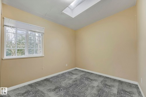Empty room featuring light carpet and a skylight - 2 Scarboro Place, St. Albert, AB - Indoor Photo Showing Other Room