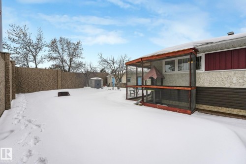 Yard layered in snow with a sunroom and a fenced backyard - 2 Scarboro Place, St. Albert, AB - Outdoor