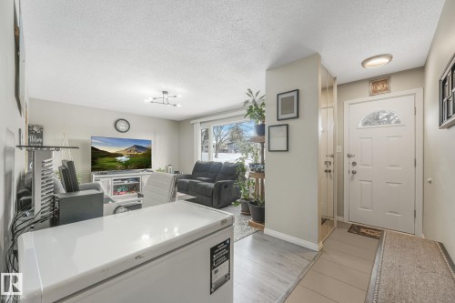 Entryway featuring a textured ceiling and light wood-style flooring - 2 Scarboro Place, St. Albert, AB - Indoor