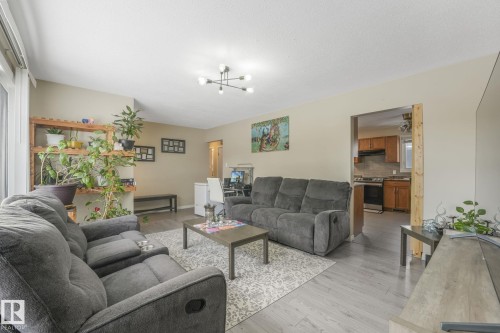 Living area featuring light wood-type flooring and hanging lights - 2 Scarboro Place, St. Albert, AB - Indoor Photo Showing Living Room