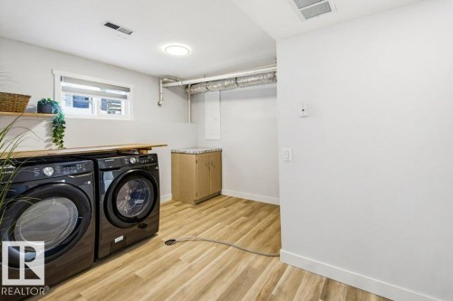 Laundry room with light wood-type flooring and washer and dryer - 7016 92A Avenue, Edmonton, AB - Indoor Photo Showing Laundry Room