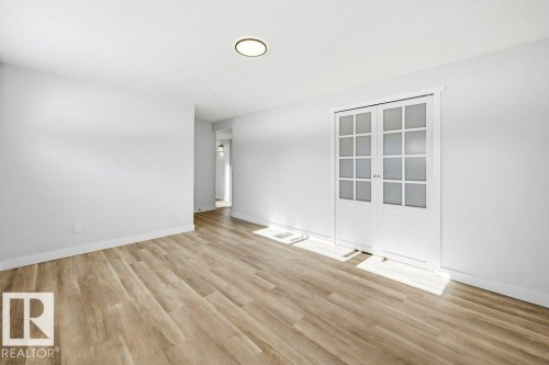 Spare room featuring light wood-type flooring and french doors - 7016 92A Avenue, Edmonton, AB - Indoor Photo Showing Other Room