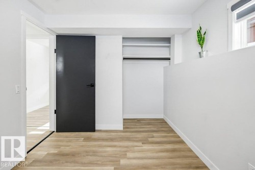 Unfurnished bedroom with light wood finished floors and a closet - 7016 92A Avenue, Edmonton, AB - Indoor Photo Showing Other Room