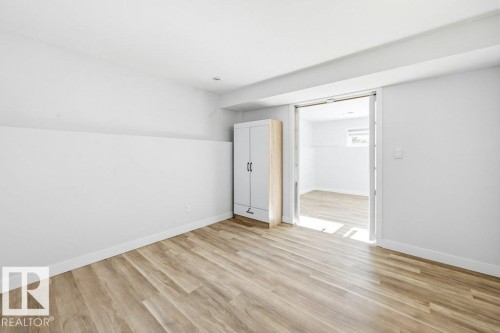 Unfurnished bedroom with light wood finished floors and baseboards - 7016 92A Avenue, Edmonton, AB - Indoor Photo Showing Other Room