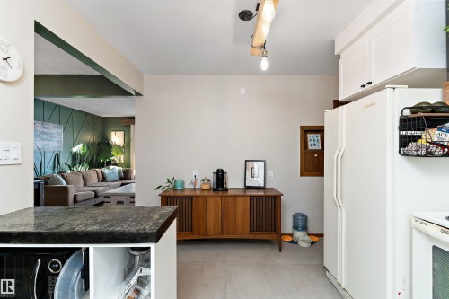 Kitchen featuring concrete flooring, electric range, white cabinets, and black microwave - 7316 100 Avenue, Edmonton, AB - Indoor