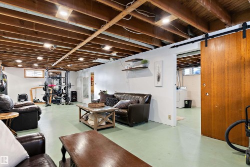 Living room with concrete flooring and washer / clothes dryer - 7316 100 Avenue, Edmonton, AB - Indoor Photo Showing Basement