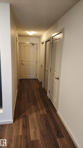 Hall featuring dark wood finished floors and a textured ceiling - 413 5521 7 Avenue, Edmonton, AB - Indoor Photo Showing Other Room