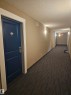 Corridor featuring a textured ceiling and dark colored carpet - 413 5521 7 Avenue, Edmonton, AB  - Indoor Photo Showing Other Room 