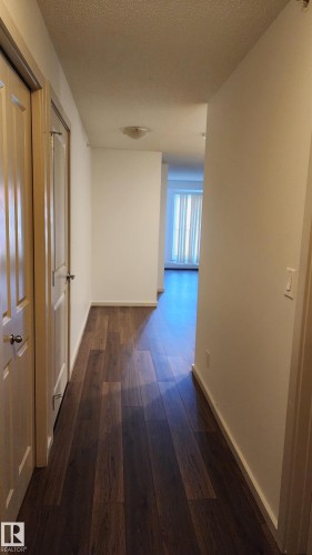 Corridor with dark wood-style floors and a textured ceiling - 413 5521 7 Avenue, Edmonton, AB - Indoor Photo Showing Other Room