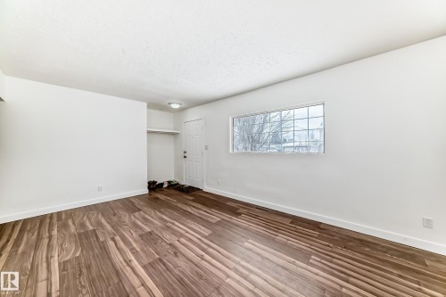 Unfurnished bedroom featuring dark wood finished floors, a closet, and a textured ceiling - 13904 135 Avenue, Edmonton, AB - Indoor Photo Showing Other Room