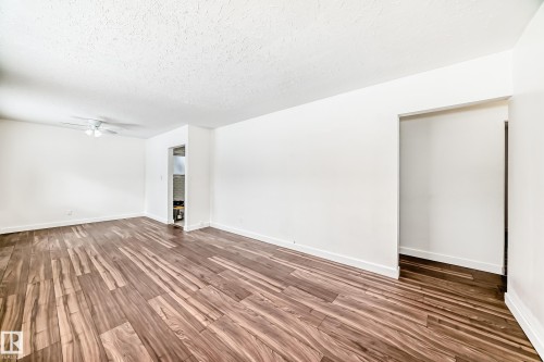 Spare room featuring dark wood-style floors, ceiling fan, and a textured ceiling - 13904 135 Avenue, Edmonton, AB - Indoor Photo Showing Other Room