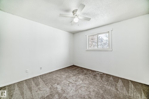 Empty room featuring carpet flooring, a ceiling fan, and a textured ceiling - 13904 135 Avenue, Edmonton, AB - Indoor Photo Showing Other Room