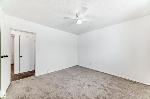 Carpeted empty room with ceiling fan and a textured ceiling - 13904 135 Avenue, Edmonton, AB - Indoor Photo Showing Other Room