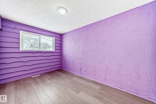 Unfurnished room with a textured wall, light wood finished floors, and a textured ceiling - 13904 135 Avenue, Edmonton, AB - Indoor
