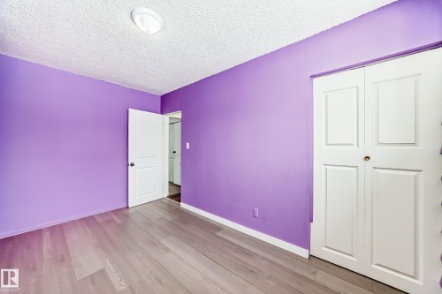 Unfurnished bedroom featuring light wood-style flooring, a textured ceiling, and a closet - 13904 135 Avenue, Edmonton, AB - Indoor Photo Showing Other Room