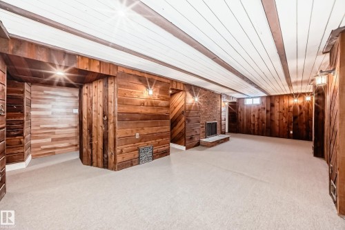 Basement featuring wooden walls and light colored carpet - 13904 135 Avenue, Edmonton, AB - Indoor Photo Showing Other Room