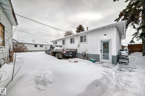 Snow covered rear of property with stucco siding and a deck - 13904 135 Avenue, Edmonton, AB - Outdoor