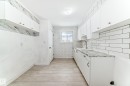 Kitchen with white cabinetry, light countertops, light wood finished floors, wallpapered walls, and backsplash - 13904 135 Avenue, Edmonton, AB  - Indoor Photo Showing Kitchen 
