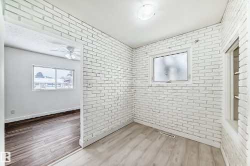 Spare room with brick wall, wood finished floors, and a ceiling fan - 13904 135 Avenue, Edmonton, AB - Indoor Photo Showing Other Room