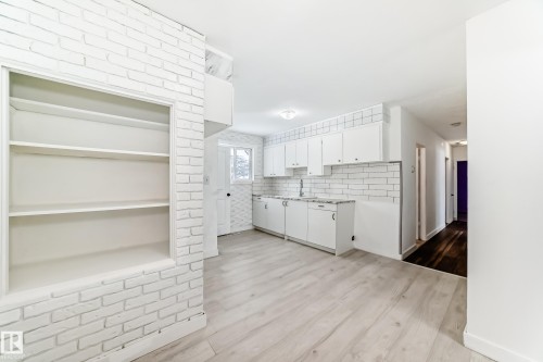 Kitchen with white cabinetry, light countertops, light wood-style flooring, and decorative backsplash - 13904 135 Avenue, Edmonton, AB - Indoor Photo Showing Kitchen