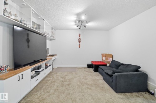 Living area with light carpet, a textured ceiling, and track lighting - 3234 Chernowski Way, Edmonton, AB - Indoor Photo Showing Other Room