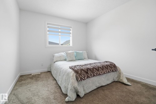 Carpeted bedroom with baseboards and a textured ceiling - 3234 Chernowski Way, Edmonton, AB - Indoor Photo Showing Bedroom
