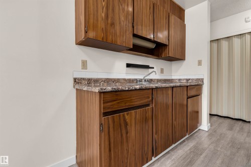 Kitchen with light wood finished floors and a textured ceiling - 25 11255 31 Avenue, Edmonton, AB - Indoor Photo Showing Kitchen