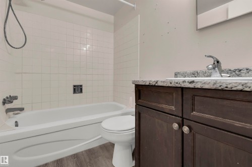 Full bathroom featuring vanity, washtub / shower combination, and light wood finished floors - 25 11255 31 Avenue, Edmonton, AB - Indoor Photo Showing Bathroom