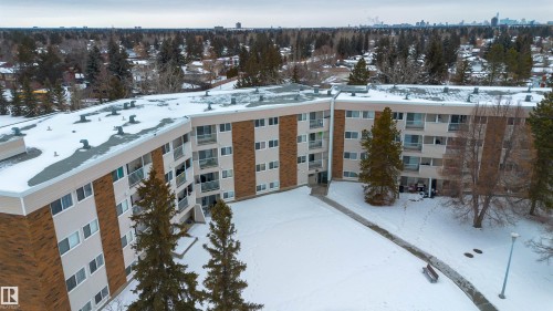 Snow covered building featuring a view of apartment building / complex - 25 11255 31 Avenue, Edmonton, AB - Outdoor