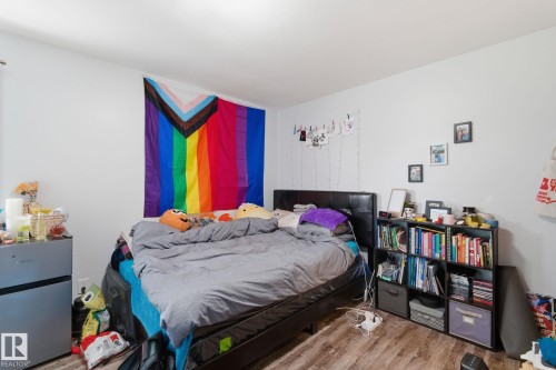 Bedroom with light wood finished floors and freestanding refrigerator - 13538 127 Street, Edmonton, AB - Indoor Photo Showing Bedroom