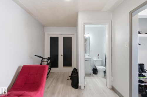 Hall featuring french doors, light wood finished floors, and a textured ceiling - 13538 127 Street, Edmonton, AB - Indoor