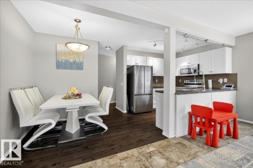 Dining room featuring baseboards and track lighting - 47 230 Edwards Drive, Edmonton, AB - Indoor Photo Showing Dining Room