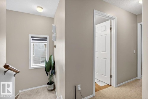 Hall featuring light colored carpet and a textured ceiling - 47 230 Edwards Drive, Edmonton, AB - Indoor Photo Showing Other Room